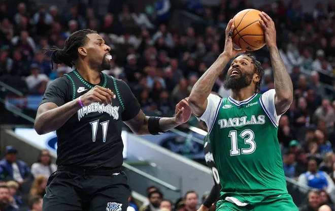 Jan 28, 2026; Dallas, Texas, USA; Dallas Mavericks forward Naji Marshall (13) shoots as Minnesota Timberwolves center Naz Reid (11) defends during the second half at American Airlines Center.