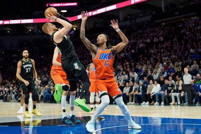 Jan 29, 2026; Minneapolis, Minnesota, USA; Minnesota Timberwolves guard Donte DiVincenzo (0) shoots as Oklahoma City Thunder forward Jaylin Williams (6) defends in the first quarter at Target Center. Mandatory Credit: Matt Blewett-Imagn Images