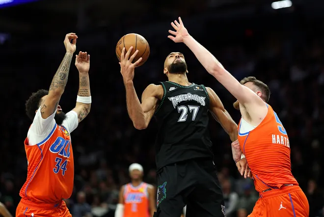 MINNEAPOLIS, MINNESOTA - JANUARY 29: Rudy Gobert #27 of the Minnesota Timberwolves rebounds the ball against Kenrich Williams #34 and Isaiah Hartenstein #55 of the Oklahoma City Thunder in the third quarter at Target Center on January 29, 2026 in Minneapolis, Minnesota. The Timberwolves defeated the Thunder 123-111. NOTE TO USER: User expressly acknowledges and agrees that, by downloading and or using this photograph, User is consenting to the terms and conditions of the Getty Images License Agreement. (Photo by David Berding/Getty Images)