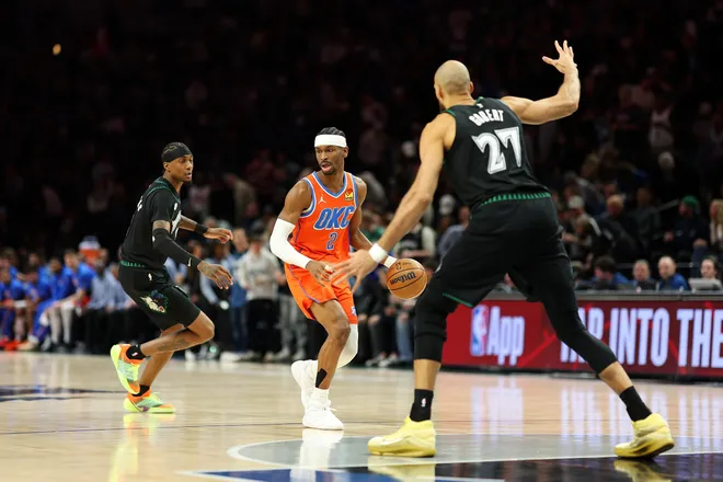 MINNEAPOLIS, MINNESOTA - JANUARY 29: Shai Gilgeous-Alexander #2 of the Oklahoma City Thunder dribbles the ball against Jaden McDaniels #3 and Rudy Gobert #27 of the Minnesota Timberwolves in the first quarter at Target Center on January 29, 2026 in Minneapolis, Minnesota. NOTE TO USER: User expressly acknowledges and agrees that, by downloading and or using this photograph, User is consenting to the terms and conditions of the Getty Images License Agreement. (Photo by David Berding/Getty Images)