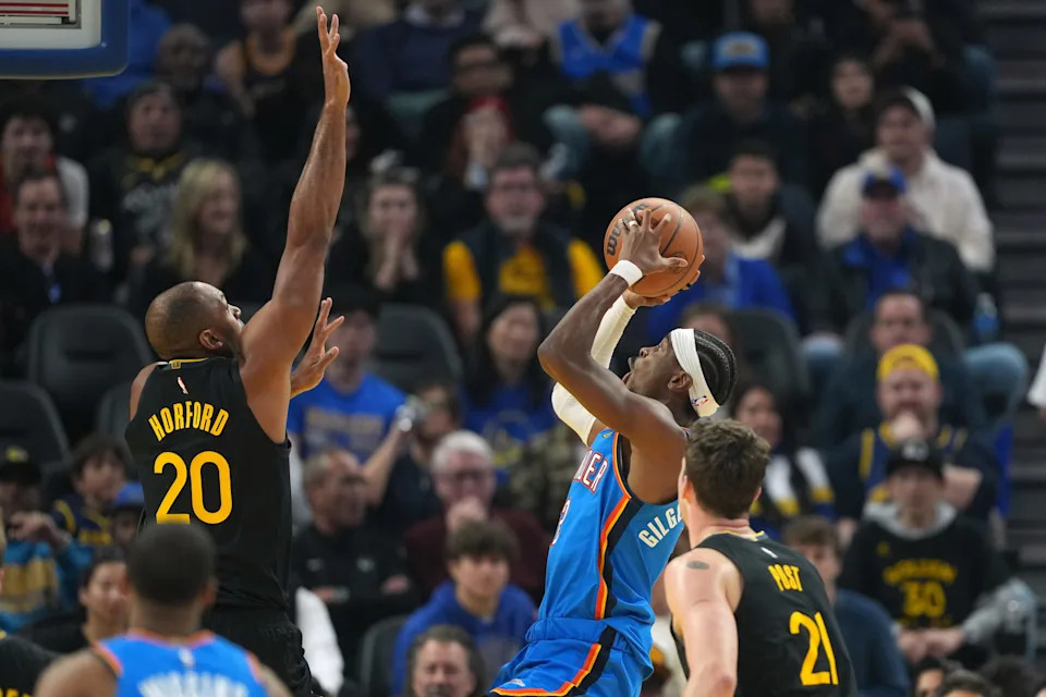 Jan 2, 2026; San Francisco, California, USA; Oklahoma City Thunder guard Shai Gilgeous-Alexander (center right) shoots against Golden State Warriors center Al Horford (20) during the first quarter at Chase Center. Mandatory Credit: Darren Yamashita-Imagn Images