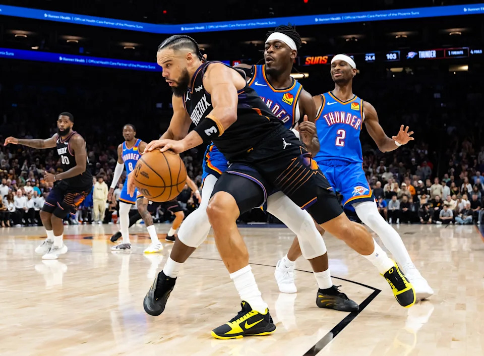 Jan 4, 2026; Phoenix, Arizona, USA; Phoenix Suns forward Dillon Brooks (3) moves the ball against Oklahoma City Thunder guard Luguentz Dort (5) and Shai Gilgeous-Alexander (2) in the second half at Mortgage Matchup Center. Mandatory Credit: Mark J. Rebilas-Imagn Images