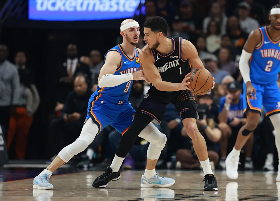 Jan 4, 2026; Phoenix, Arizona, USA; Phoenix Suns guard Devin Booker (1) against Oklahoma City Thunder guard Alex Caruso (9) in the first half at Mortgage Matchup Center. Mandatory Credit: Mark J. Rebilas-Imagn Images