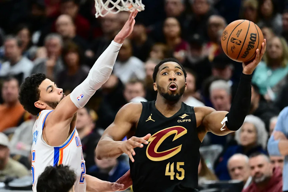 Jan 19, 2026; Cleveland, Ohio, USA; Cleveland Cavaliers guard Donovan Mitchell (45) drives to the basket against Oklahoma City Thunder guard Ajay Mitchell (25) during the second half at Rocket Arena. Mandatory Credit: Ken Blaze-Imagn Images