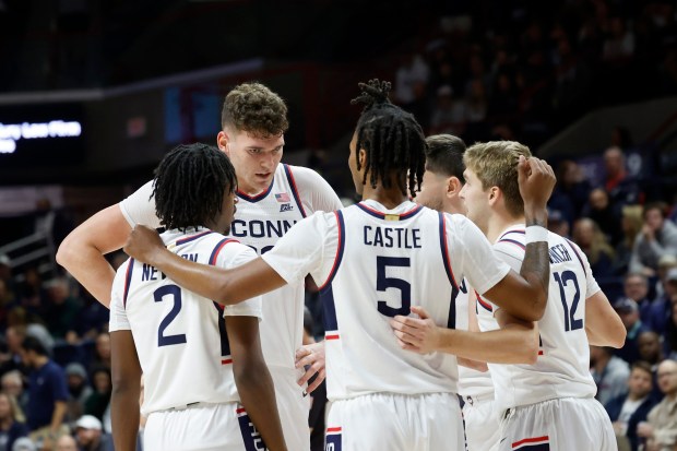UConn players including Donovan Clingan, facing, Tristen Newton (2), Stephon Castle (5) and Cam Spencer (12) huddle during the first half of an NCAA college basketball game against Northern Arizona, Monday, Nov. 6, 2023, in Storrs, Conn.  All four will make their Summer League debuts this month. (AP Photo/Mary Schwalm)