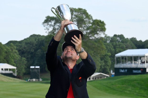 Keegan Bradley holds the championship trophy after winning the Travelers Championship golf tournament at TPC River Highlands, Sunday, June 22, 2025, in Cromwell, Conn. (AP Photo/Jessica Hill)