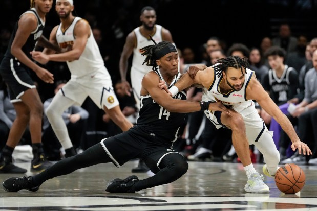 Brooklyn Nets guard Terance Mann (14) fights for control of the ball with Denver Nuggets guard Jamal Murray during the first half of an NBA basketball game, Sunday, Jan. 4, 2026, in New York. (AP Photo/Yuki Iwamura)