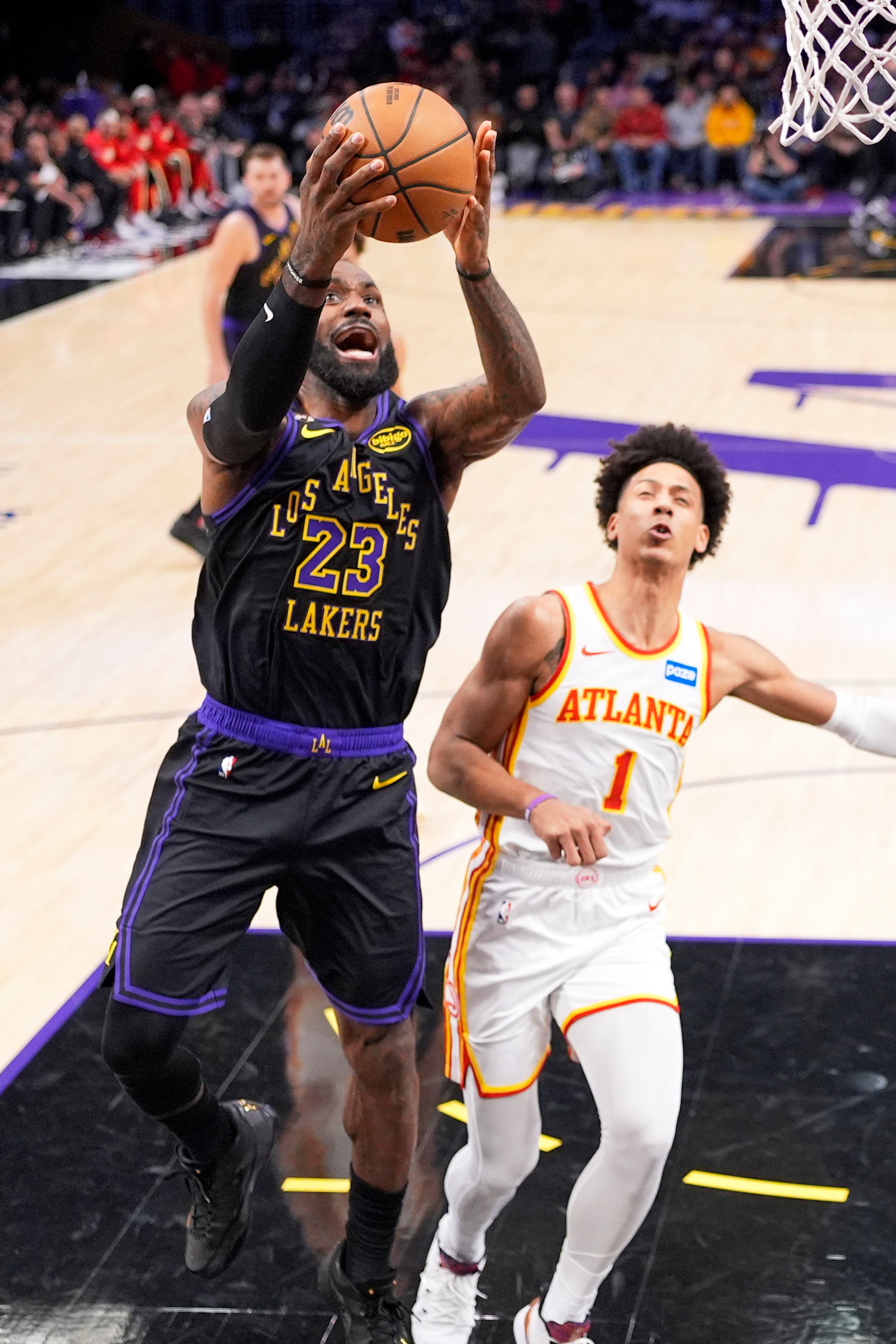 Lakers forward LeBron James, left, shoots as Atlanta Hawks forward...