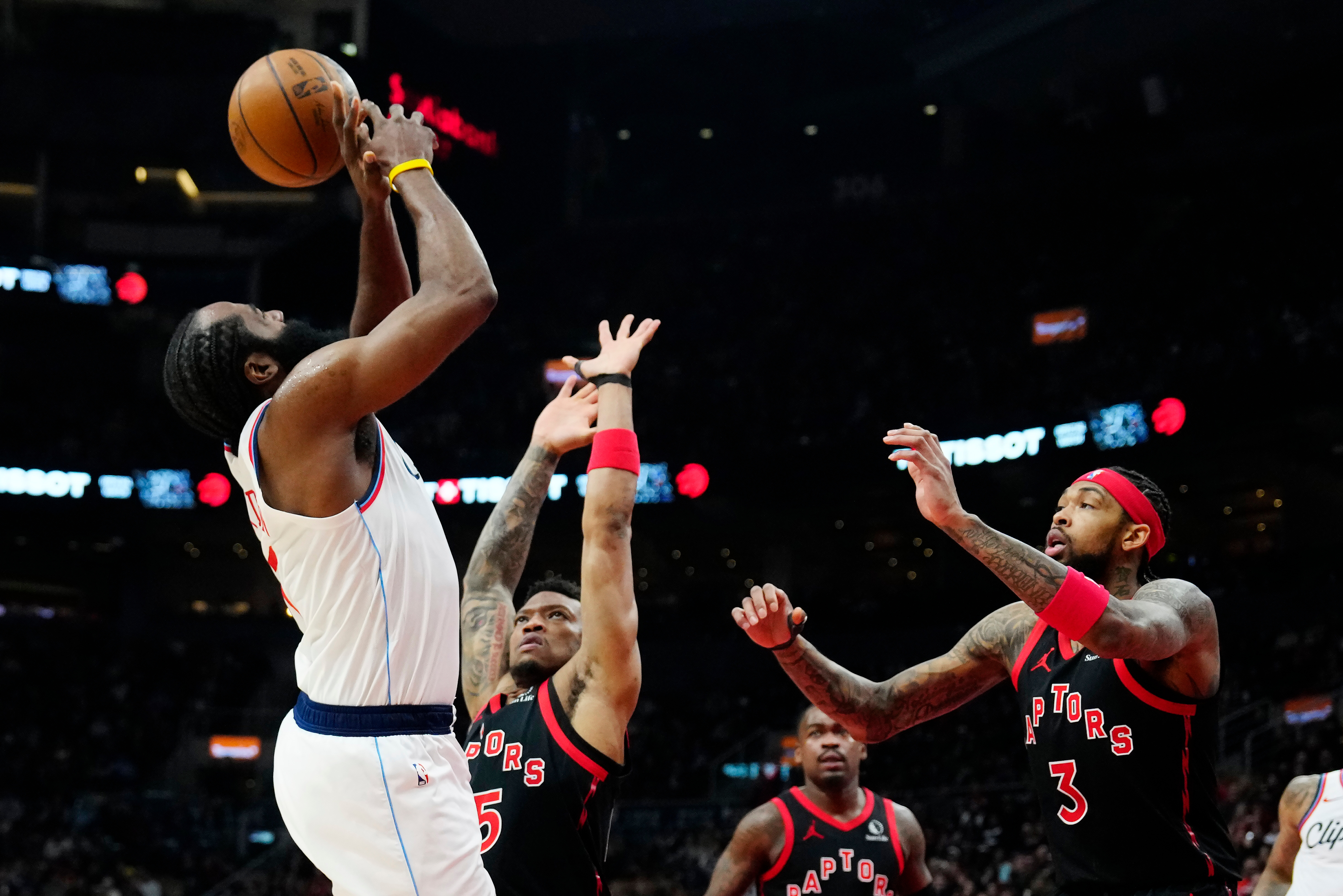 Clippers star James Harden, left, is fouled as the Toronto...
