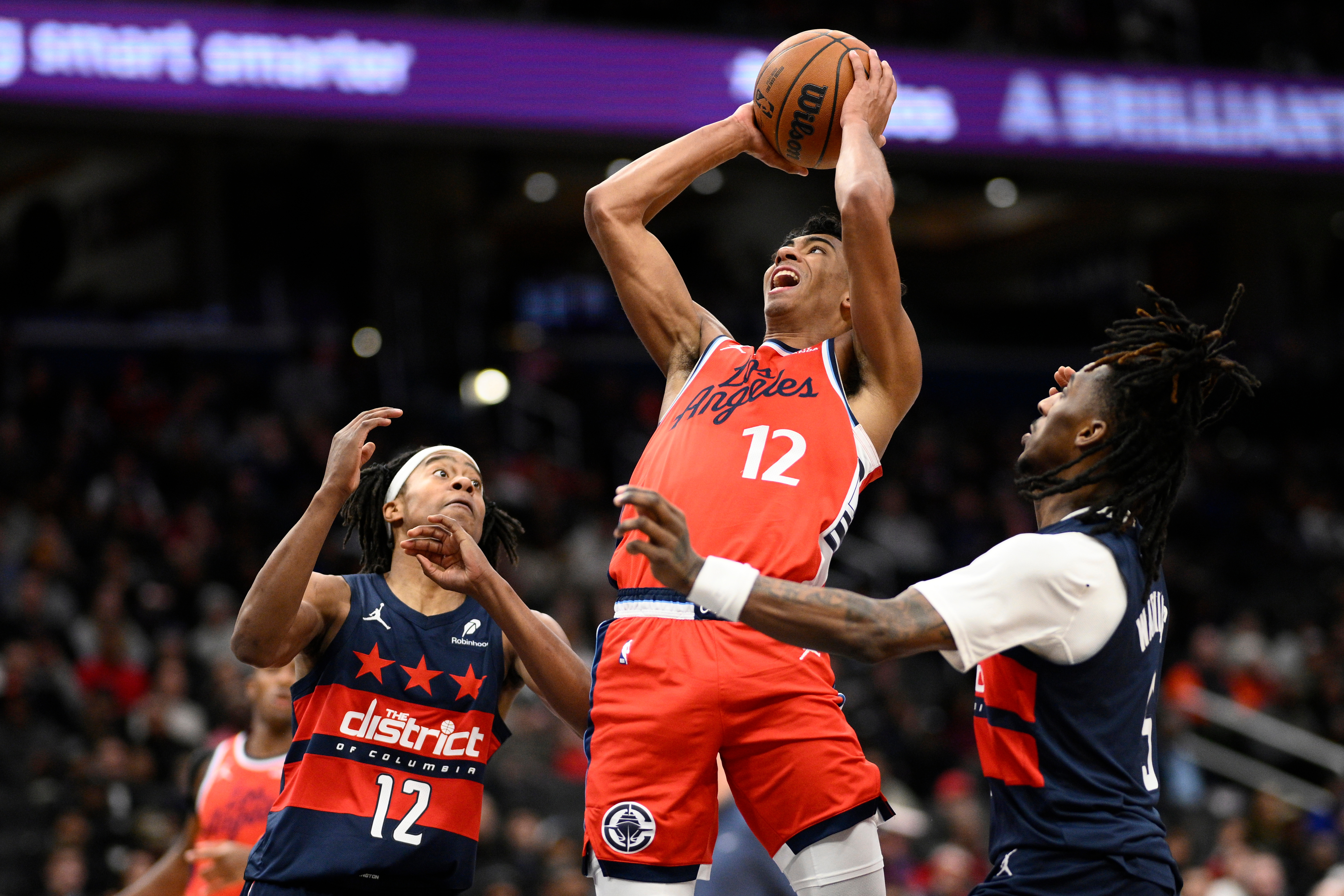 Clippers guard Cam Christie, center, looks to shoot as Washington...