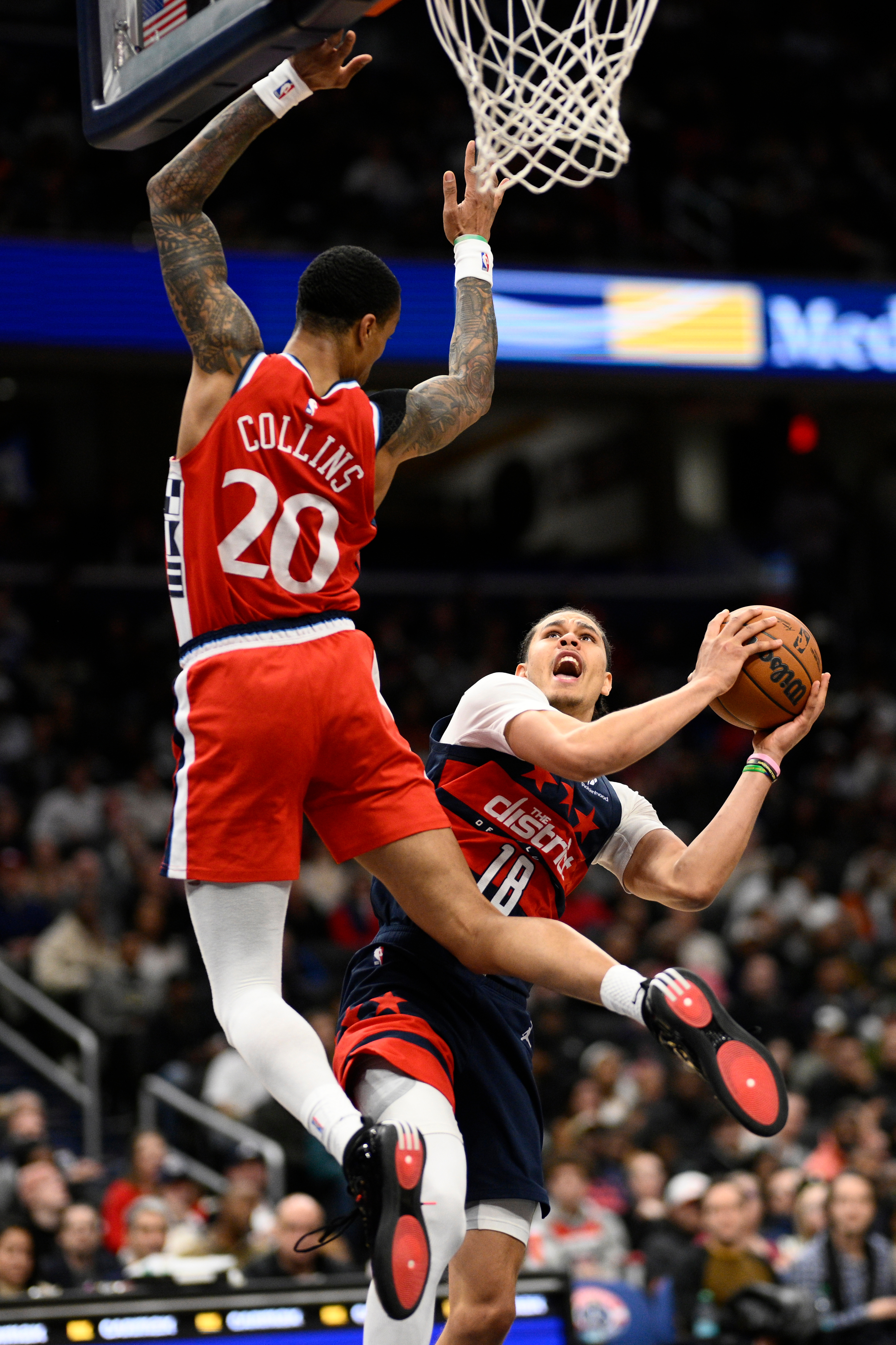 Clippers forward John Collins, left, fouls Washington Wizards forward Kyshawn...