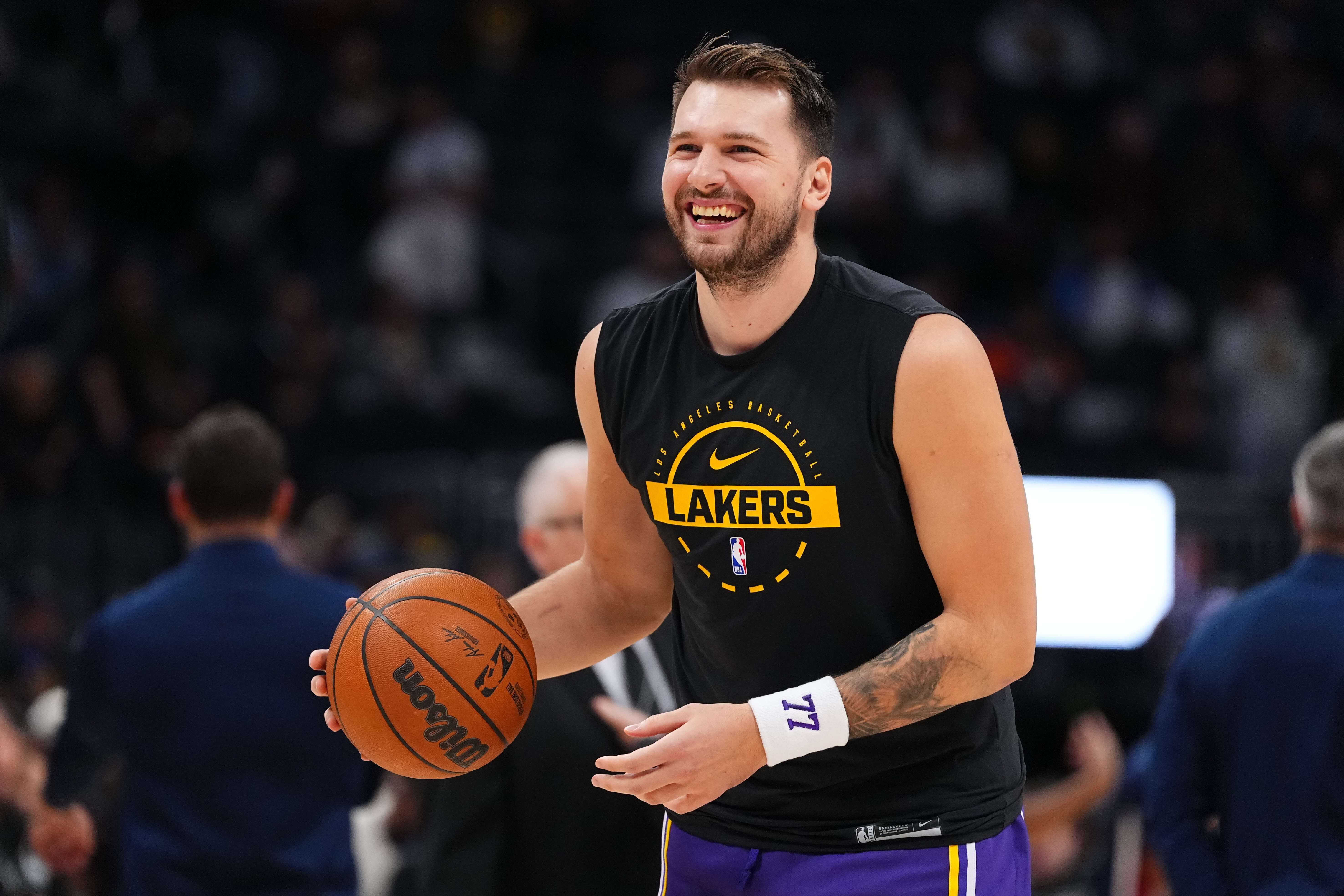 Lakers star Luka Doncic smiles while warming up against the...