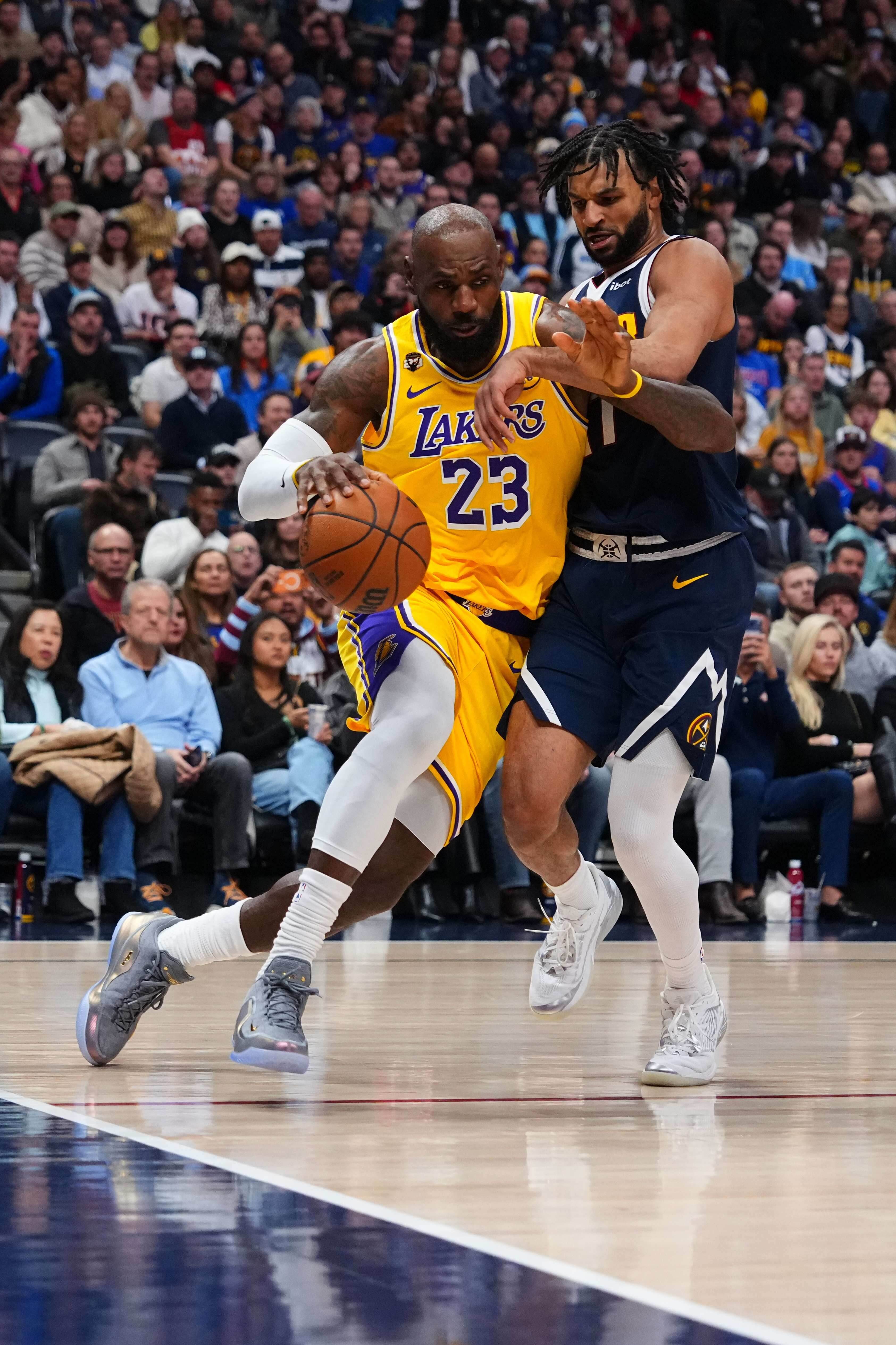 Lakers forward LeBron James, left, drives the baseline as Denver...