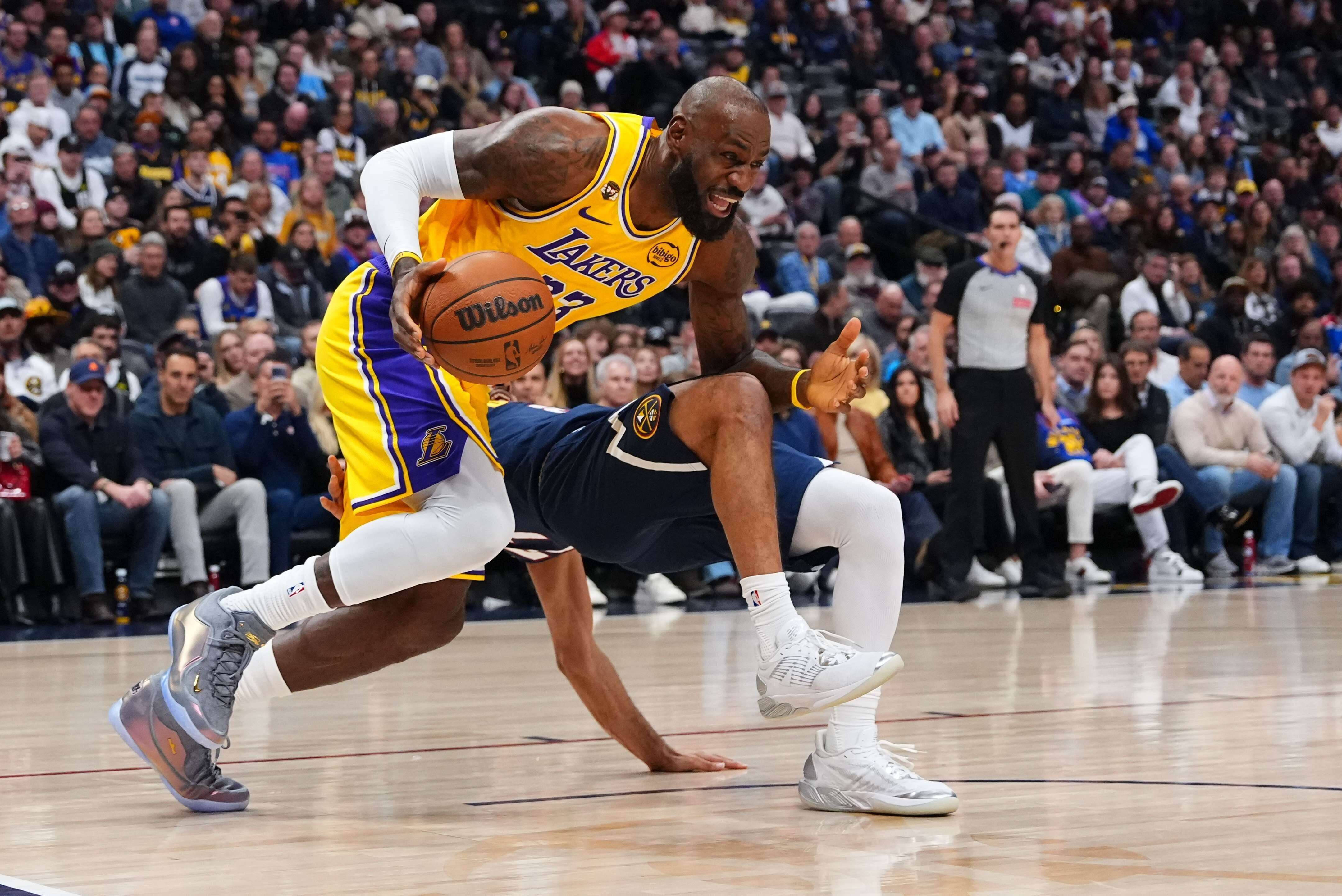 Lakers forward LeBron James, left, fouls Denver Nuggets guard Jamal...