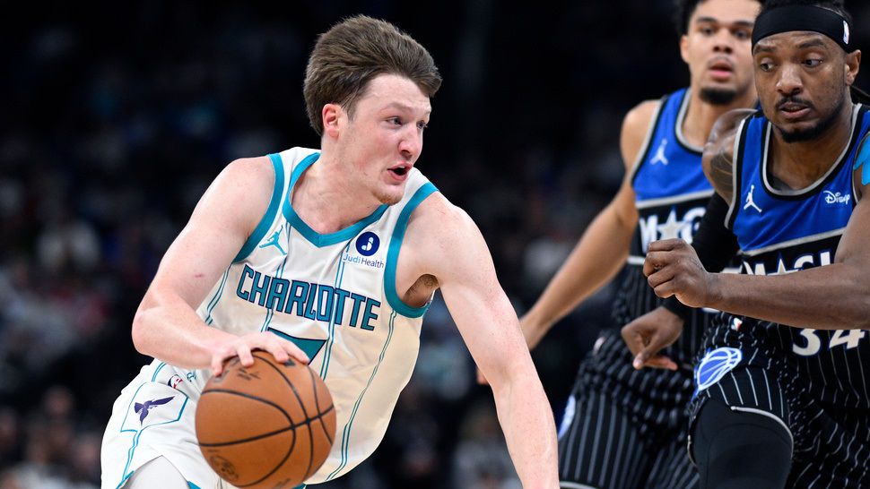 Charlotte Hornets guard Kon Knueppel, left, drives to the basket as Orlando Magic center Wendell Carter Jr., right, and forward Noah Penda, second from right, defend during the first half of an NBA basketball game, Thursday, Jan. 22, 2026, in Orlando, Fla. (AP Photo/Phelan M. Ebenhack)
