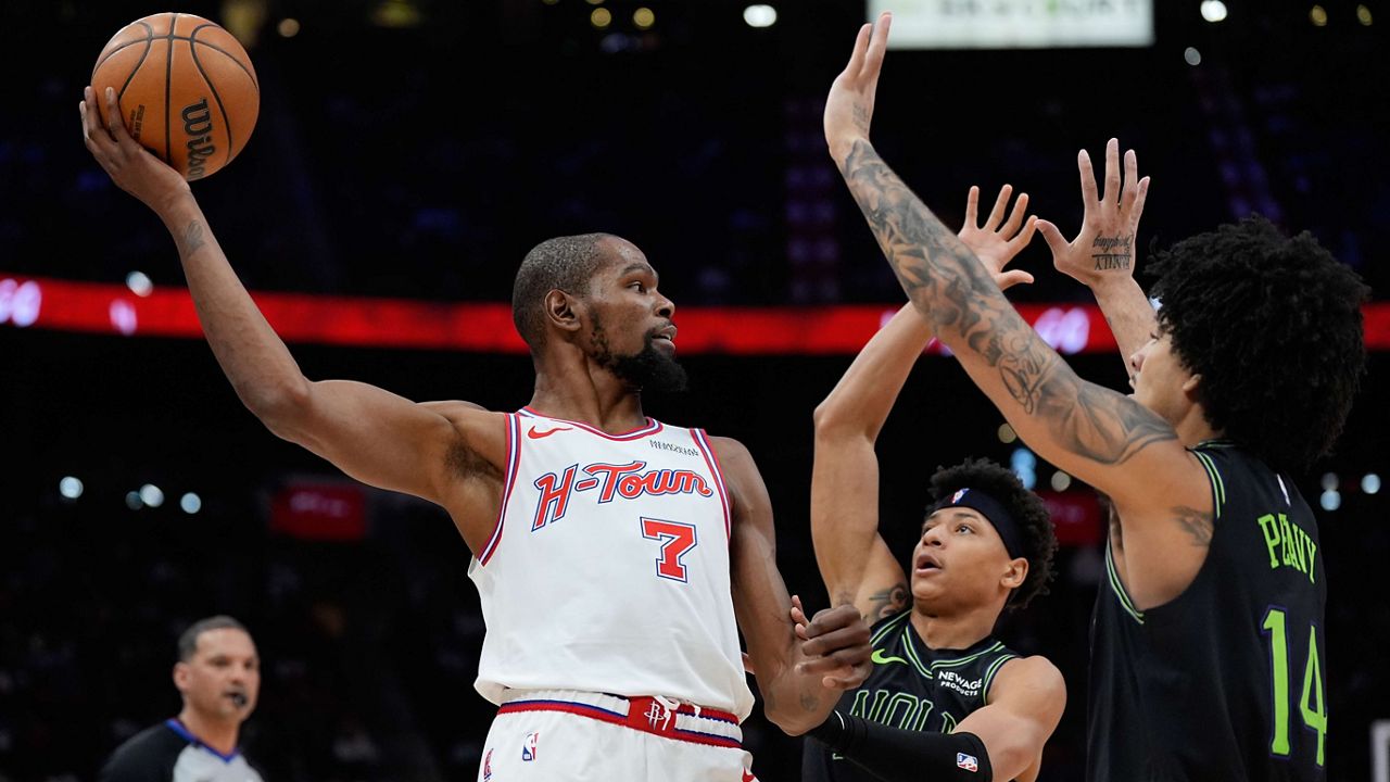 Houston Rockets forward Kevin Durant (7) looks to pass over New Orleans Pelicans guard Jeremiah Fears (0) and guard Micah Peavy (14) during the second half of an NBA basketball game in Houston, Sunday, Jan. 18, 2026. (AP Photo/Ashley Landis)