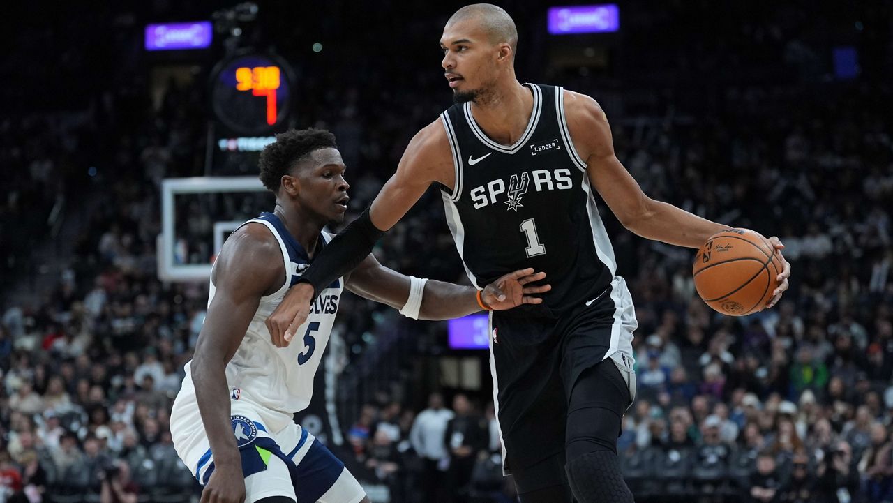 San Antonio Spurs forward Victor Wembanyama (1) drives against Minnesota Timberwolves guard Anthony Edwards (5) during the second half of an NBA basketball game in San Antonio, Saturday, Jan. 17, 2026. (AP Photo/Eric Gay)
