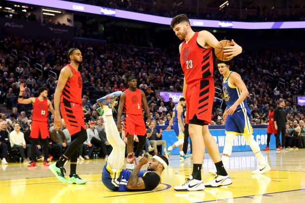 Golden State Warriors' Gary Payton II (0) ends up on the floor after he was fouled by Portland Trail Blazers' Donovan Clingan (23) in the second quarter of an NBA game at Chase Center in San Francisco, Calif., on Tuesday, Jan. 13, 2026. (Ray Chavez/Bay Area News Group)