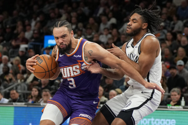 Phoenix Suns forward Dillon Brooks (3) drives on Brooklyn Nets guard Cam Thomas during the second half of an NBA basketball game, Tuesday, Jan. 27, 2026, in Phoenix. (AP Photo/Rick Scuteri)