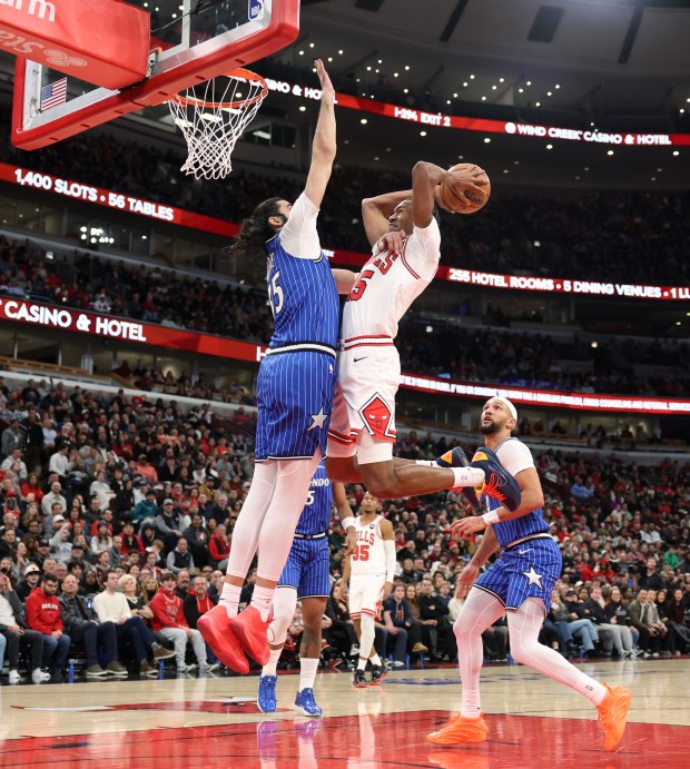 Bulls forward Julian Phillips, right, gets a stiff-arm from Magic center Goga Bitadze in the second quarter at the United Center on Jan. 2, 2026, in Chicago. (John J. Kim/Chicago Tribune)