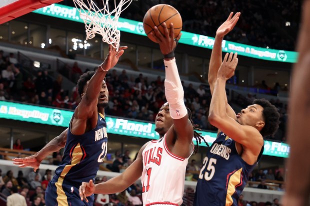 Bulls guard Ayo Dosunmu (11) puts up a shot as Pelicans center Yves Missi (21) and forward Trey Murphy III (25) defend in the first half at the United Center on Wednesday, Dec. 31, 2025. (Terrence Antonio James/Chicago Tribune)