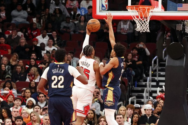 Bulls forward/guard Isaac Okoro (35) lofts a shot as Pelicans guard Jordan Poole (3) defends in the second half at the United Center on Wednesday, Dec. 31, 2025. The Bulls won 134 - 118. (Terrence Antonio James/Chicago Tribune)