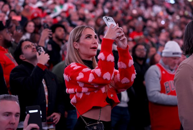 A fan documents the moment during a ceremony to retire Derrick Rose's #1 jersey by the Chicago Bulls at the United Center in Chicago on Jan. 24, 2026. (Chris Sweda/Chicago Tribune)