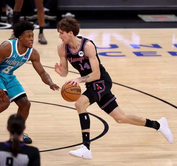 Chicago Bulls forward Matas Buzelis (14) drives on Charlotte Hornets guard Collin Sexton (8) in the first half of a game at the United Center in Chicago on Jan. 3, 2026. (Chris Sweda/Chicago Tribune)