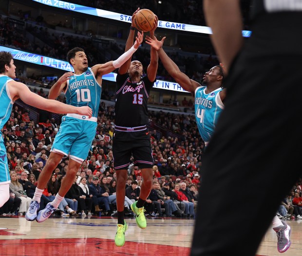 Chicago Bulls forward Julian Phillips (15) fights for a rebound with Charlotte Hornets guards Josh Green (10) and Sion James (4) in the second half of a game at the United Center in Chicago on Jan. 3, 2026. (Chris Sweda/Chicago Tribune)