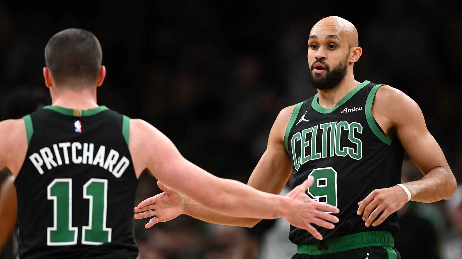 Boston Celtics guard Payton Pritchard (11) high-fives guard Derrick White (9) during the first half of a game against the San Antonio Spurs at the TD Garden.