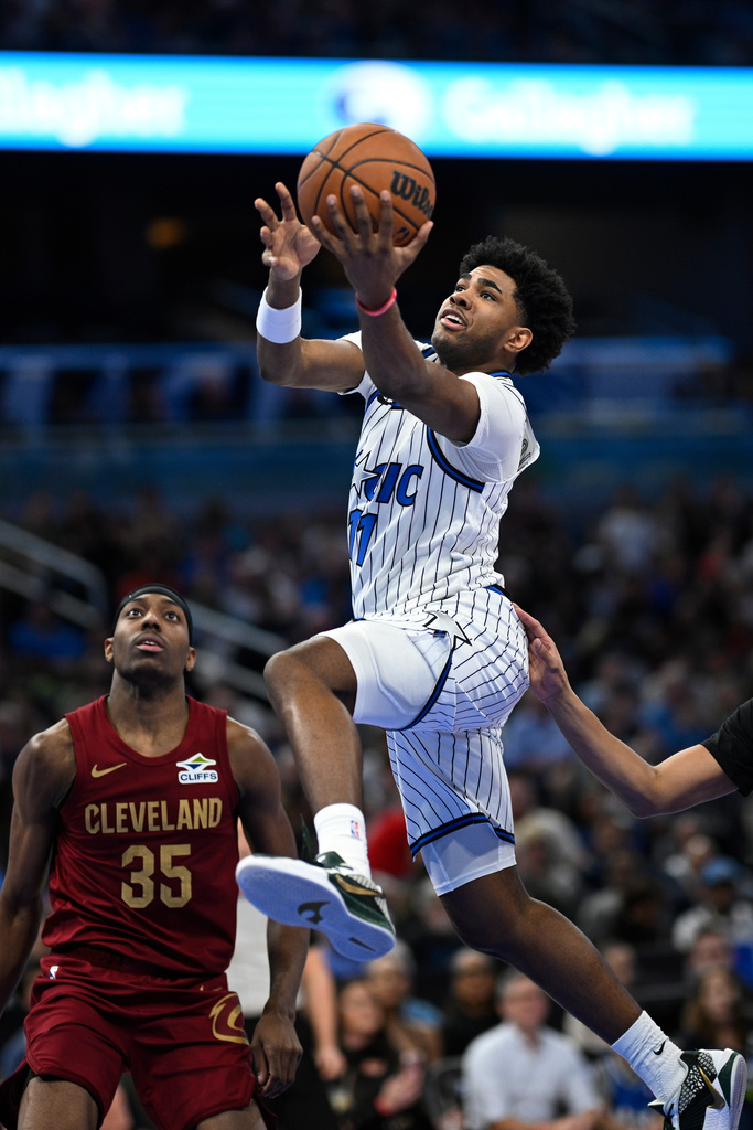 Orlando Magic guard Jase Richardson (11) goes up to shoot as Cleveland Cavaliers forward Nae'qwan Tomlin (35) looks on during the first half of an NBA basketball game, Saturday, Jan. 24, 2026, in Orlando, Fla. (AP Photo/Phelan M. Ebenhack)