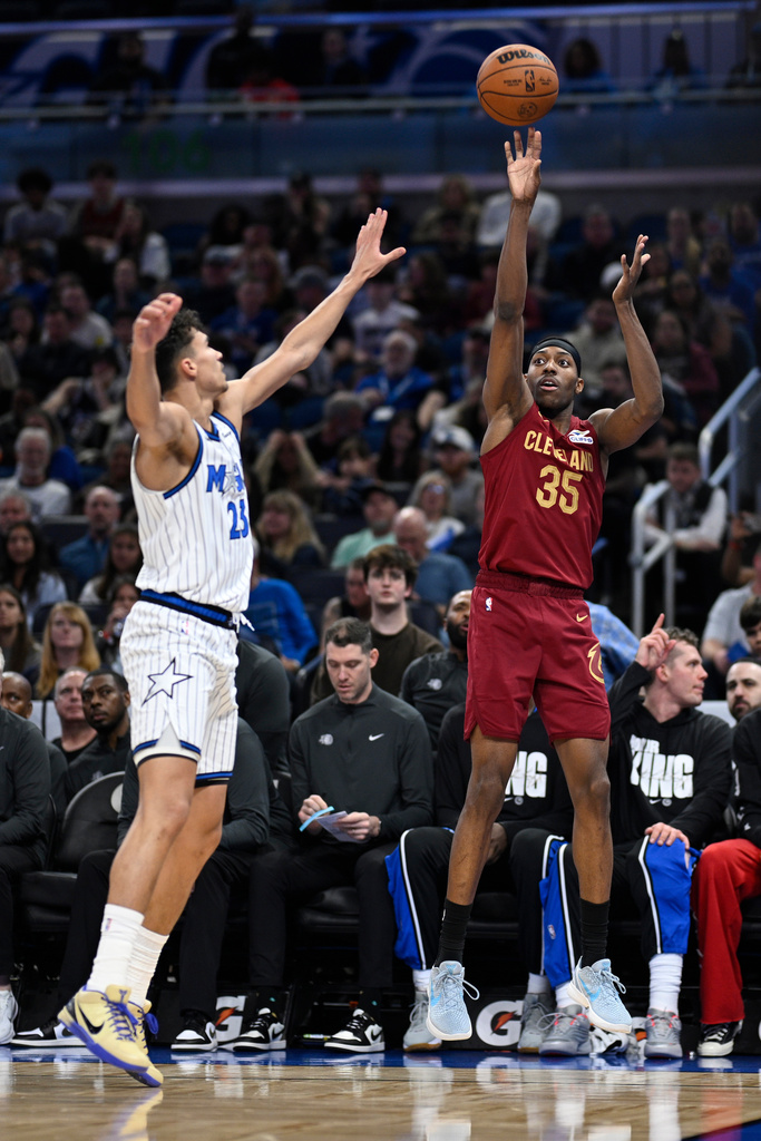 Cleveland Cavaliers forward Nae'qwan Tomlin (35) attempts a 3-point shot as Orlando Magic forward Tristan da Silva, left, defends during the first half of an NBA basketball game, Saturday, Jan. 24, 2026, in Orlando, Fla. (AP Photo/Phelan M. Ebenhack)