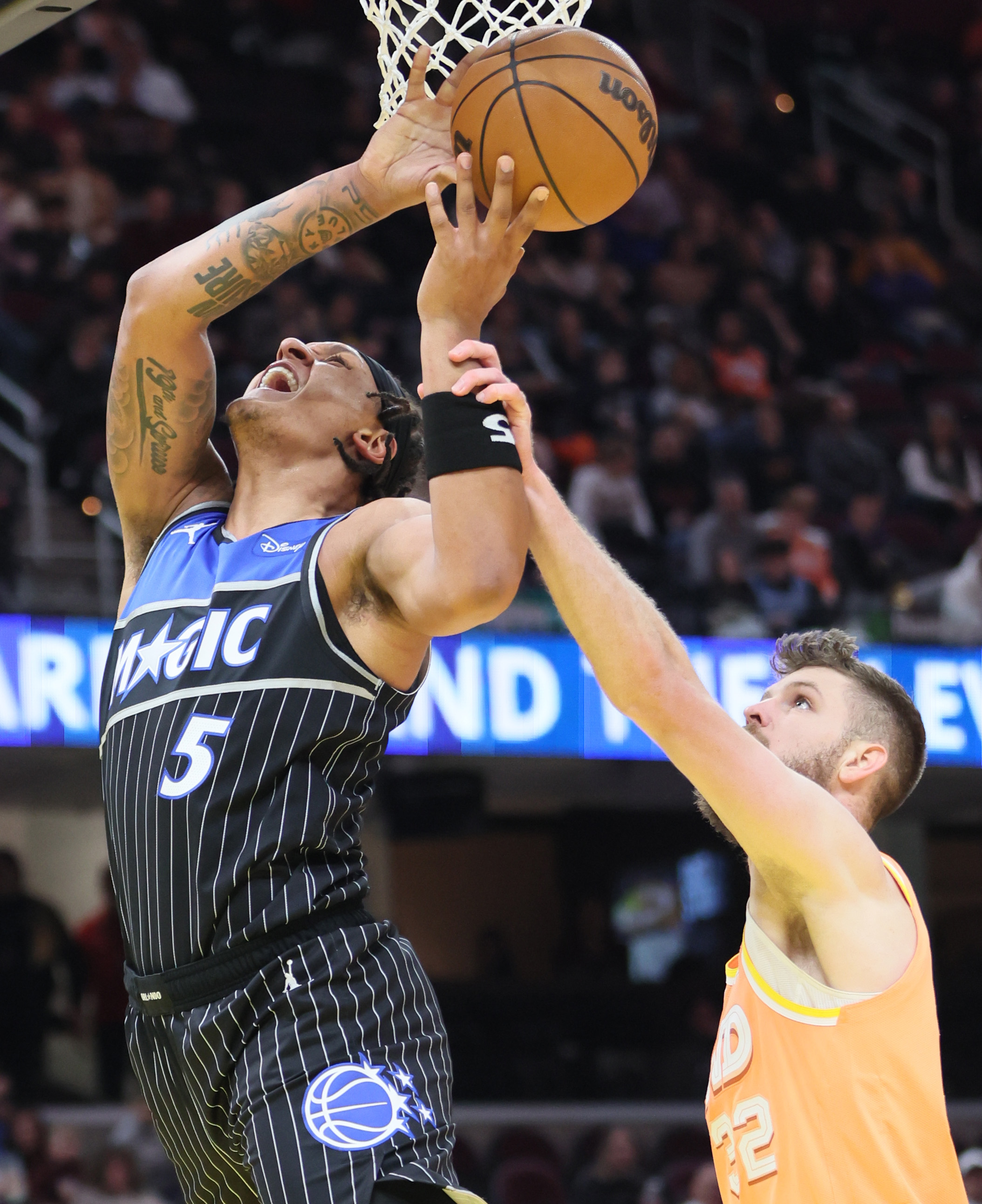 Cleveland Cavaliers forward Dean Wade (R) fouls Orlando Magic forward Paolo Banchero on a shot attempt in the second half. 