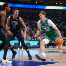 Dallas Mavericks forward Cooper Flagg (32) drives to the basket against Brooklyn Nets forward Michael Porter Jr. (17) and center Nic Claxton during the first half of an NBA basketball game Monday, Jan. 12, 2026, in Dallas. (AP Photo/Julio Cortez)