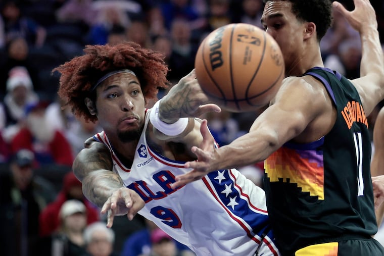 Sixers # 9 Kelly Oubre Jr. passes the ball around Suns # 11 Oso Ighodaro in the first half of the Phoenix Suns vs. Philadelphia 76ers (Sixers) NBA game at Xfinity Mobile Arena in Philadelphia on Tuesday, Jan. 20, 2026.