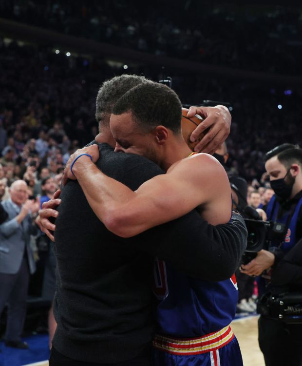NEW YORK, NEW YORK - DECEMBER 14: Stephen Curry #30 of the Golden State Warriors hugs his Dad Dell Curry after making a three point basket to break Ray Allen's record for the most all-time against the New York Knicks during their game at Madison Square Garden on December 14, 2021 in New York City. NOTE TO USER: User expressly acknowledges and agrees that, by downloading and or using this photograph, User is consenting to the terms and conditions of the Getty Images License Agreement. (Photo by Al Bello/Getty Images)