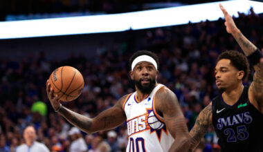 Royce O'Neale #00 of the Phoenix Suns drives inside for a shot against P.J. Washington #25 of the D...