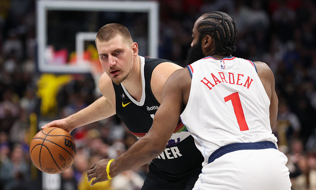 DENVER, COLORADO - JANUARY 30: Nikola Jokic #15 of the Denver Nuggets dribbles as James Harden #1 o...