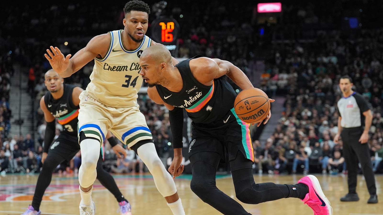San Antonio Spurs forward/center Victor Wembanyama (1) dribbles against Milwaukee Bucks forward Giannis Antetokounmpo (34) in the first half at Frost Bank Center. 