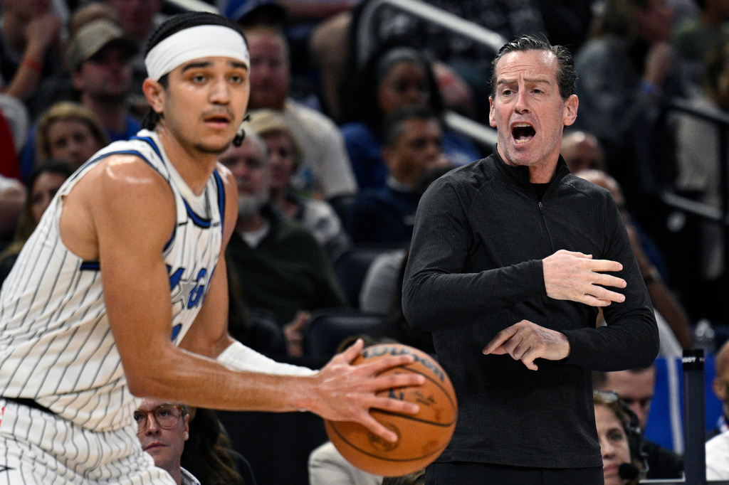 Cleveland Cavaliers head coach Kenny Atkinson, right, shouts instructions as Orlando Magic guard Anthony Black, left, controls the ball during the first half of an NBA basketball game, Saturday, Jan. 24, 2026, in Orlando, Fla. (AP Photo/Phelan M. Ebenhack)