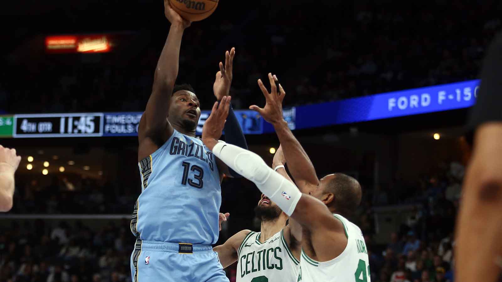 Mar 31, 2025; Memphis, Tennessee, USA; Memphis Grizzlies forward Jaren Jackson Jr. (13) shoots as Boston Celtics guard Derrick White (9) and Boston Celtics guard Jrue Holiday (4) defend during the fourth quarter at FedExForum. Mandatory Credit: Petre Thomas-Imagn Images
