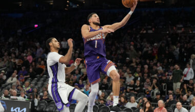 Phoenix Suns guard Devin Booker (1) drives past Sacramento Kings forward Keegan Murray, left, durin...
