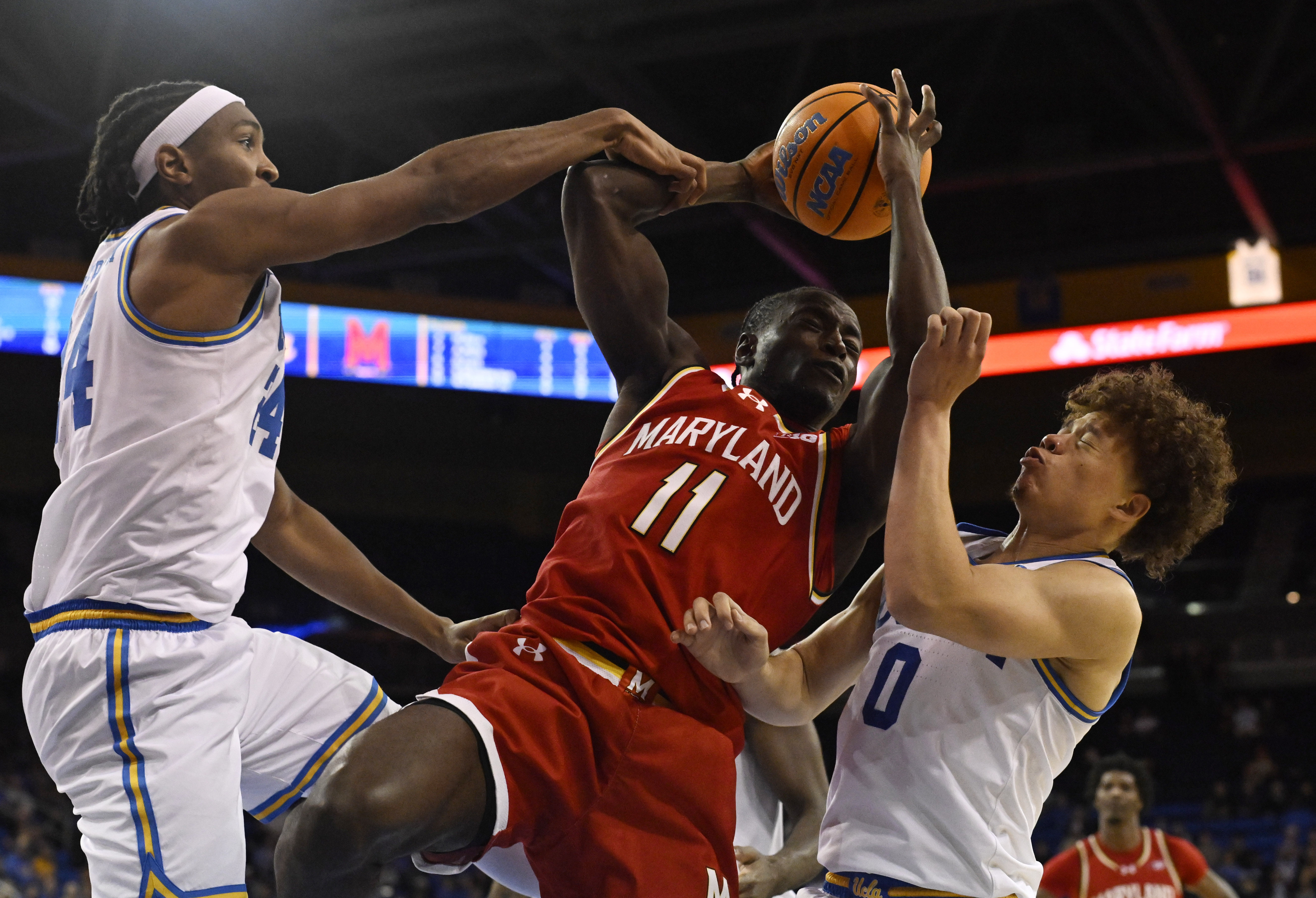 Guard George Turkson Jr. #11 of the Maryland Terrapins rebounds...