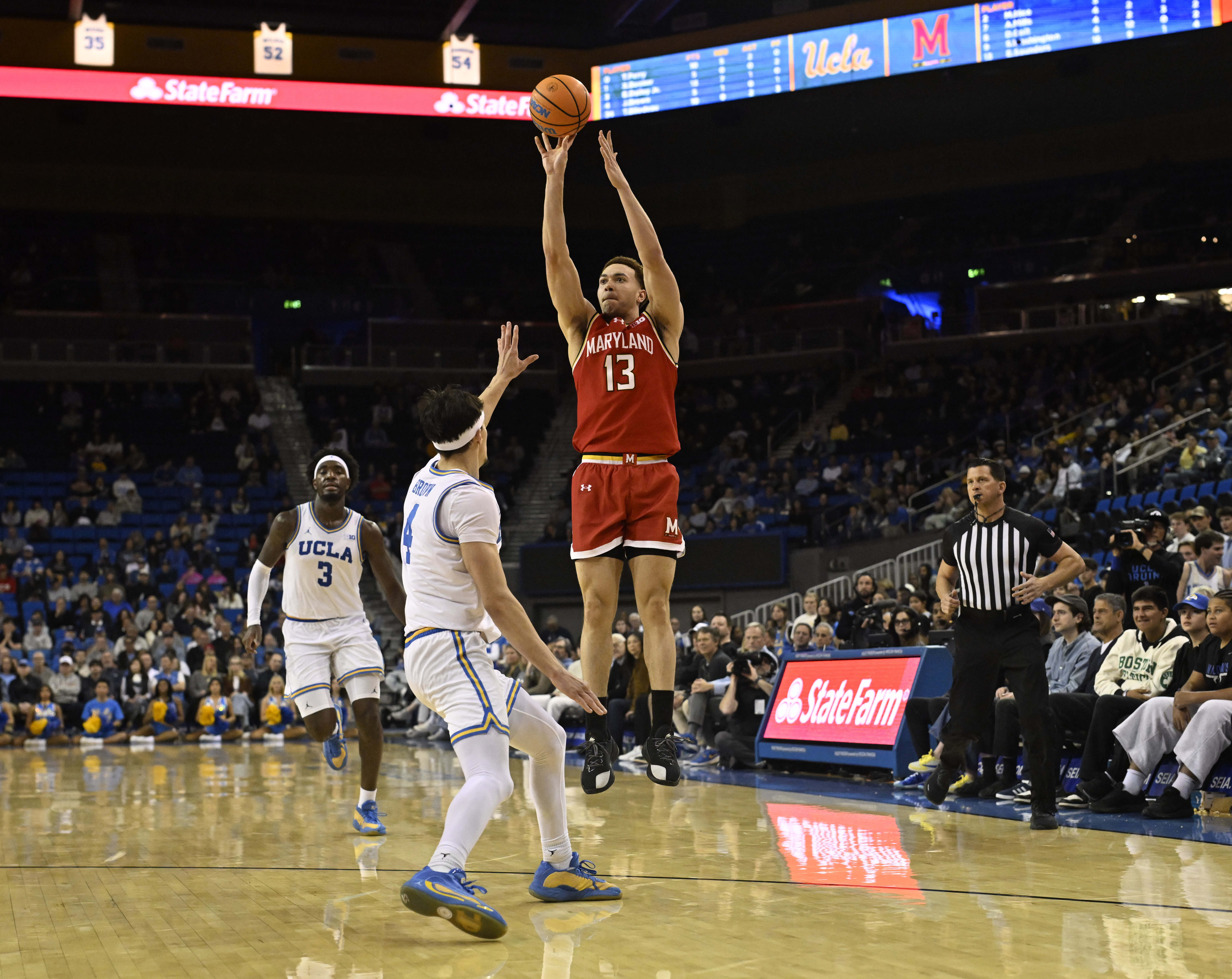 Forward Elijah Saunders #13 of the Maryland Terrapins shoots over...