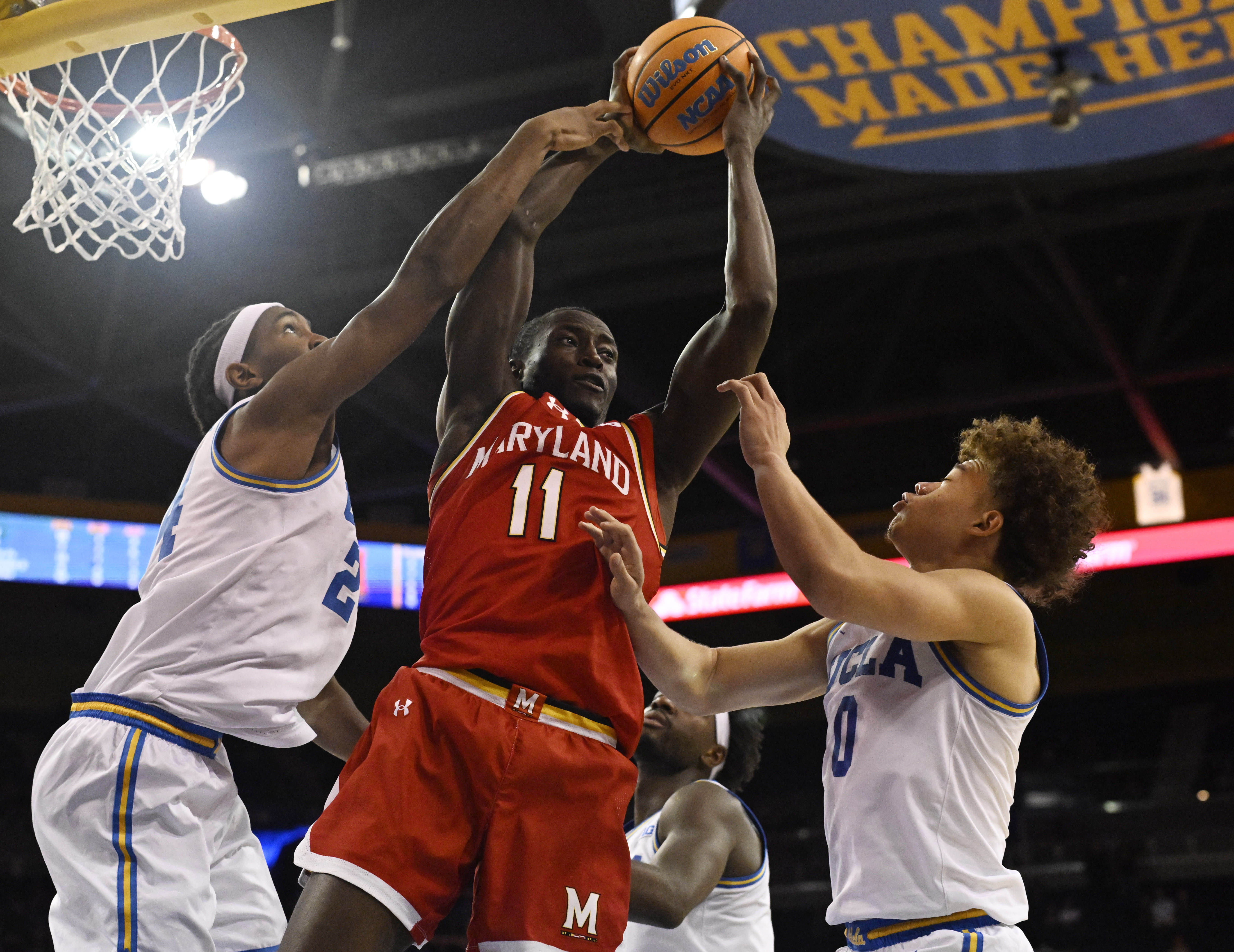Guard George Turkson Jr. #11 of the Maryland Terrapins rebounds...
