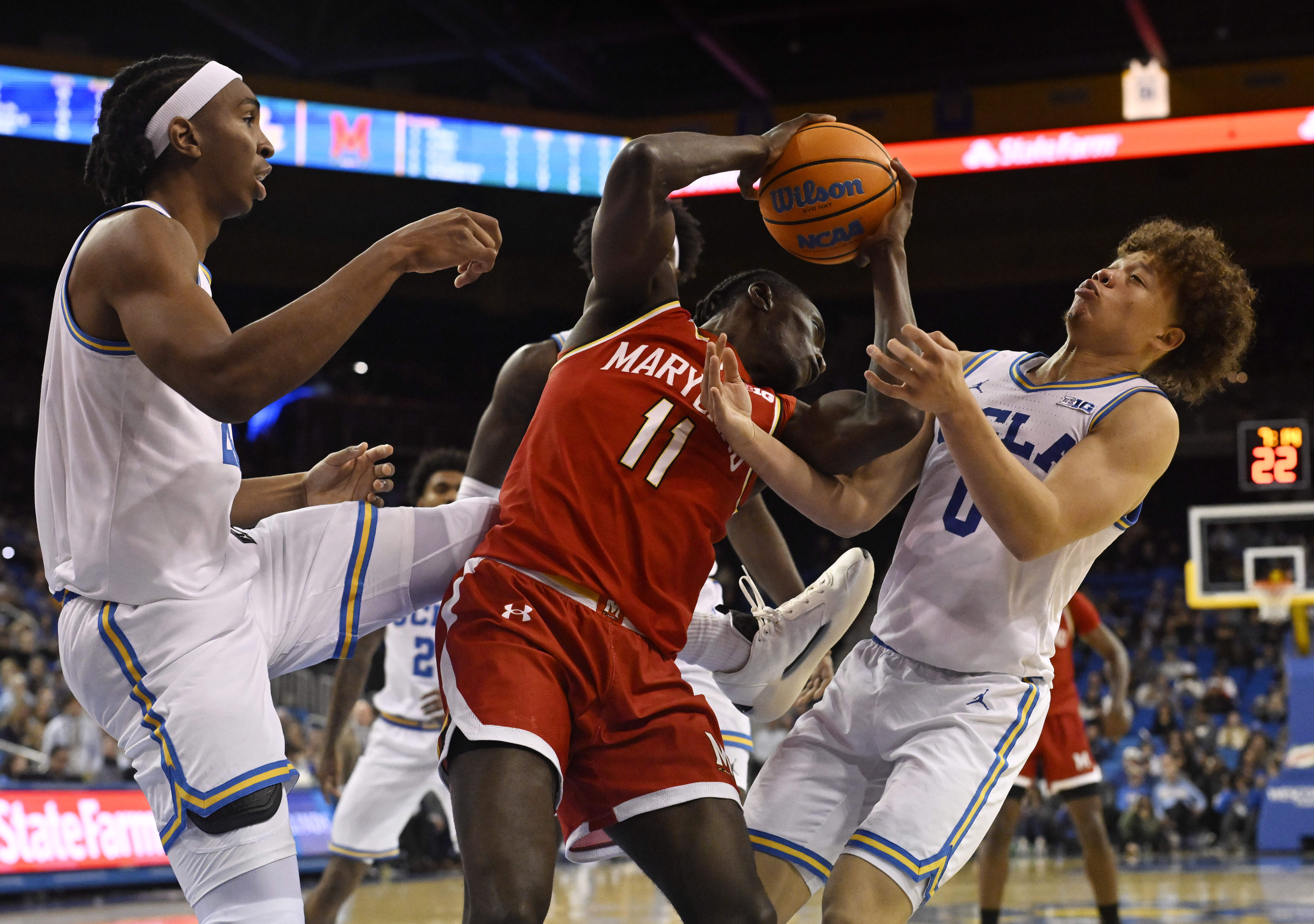 Guard George Turkson Jr. #11 of the Maryland Terrapins rebounds...