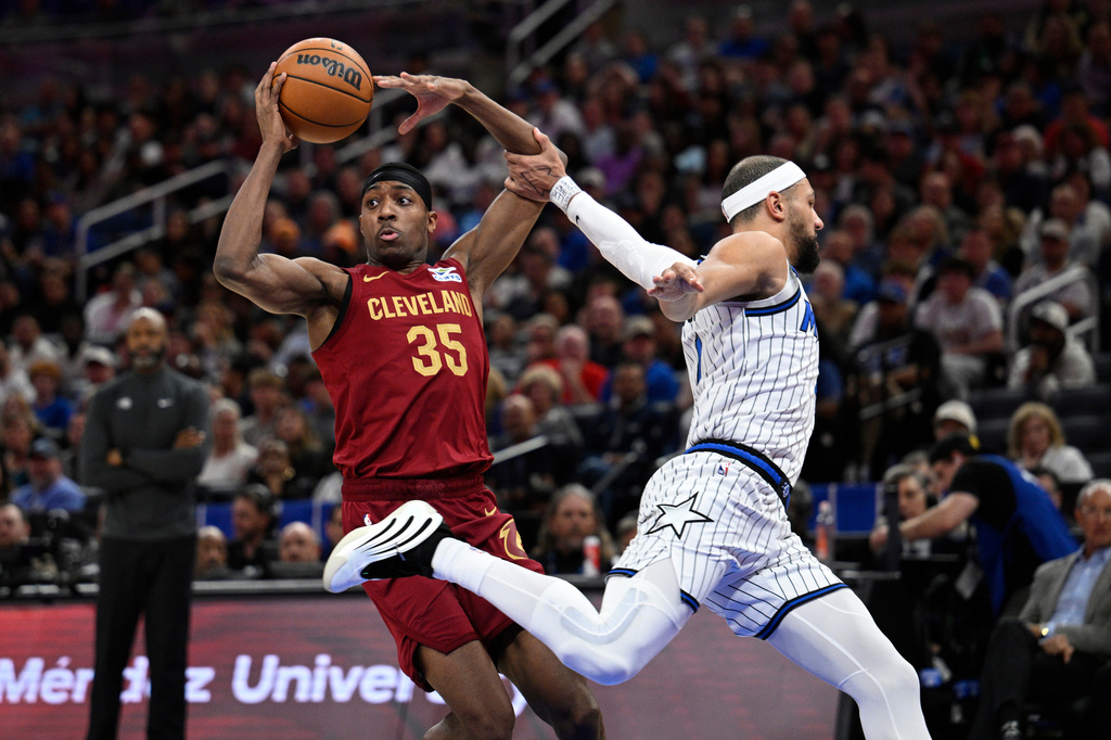 Cleveland Cavaliers forward Nae'qwan Tomlin (35) is fouled by Orlando Magic guard Jalen Suggs, right, while driving to the basket during the first half of an NBA basketball game, Saturday, Jan. 24, 2026, in Orlando, Fla. (AP Photo/Phelan M. Ebenhack)