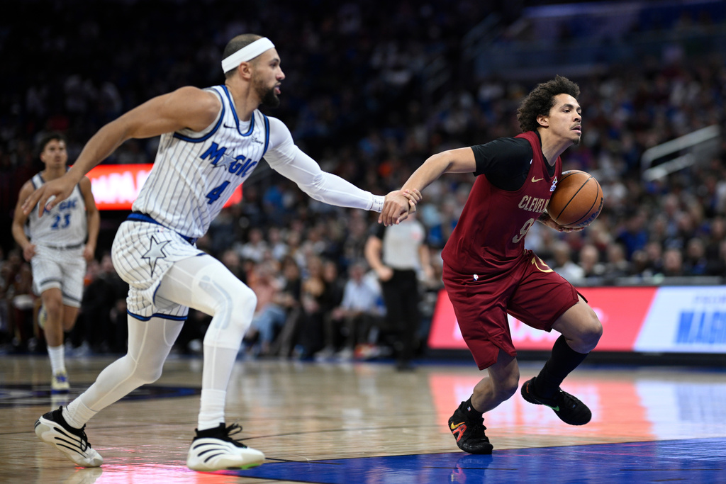Cleveland Cavaliers guard Craig Porter Jr. (9) is fouled by Orlando Magic guard Jalen Suggs (4) while driving to the basket during the first half of an NBA basketball game, Saturday, Jan. 24, 2026, in Orlando, Fla. (AP Photo/Phelan M. Ebenhack)