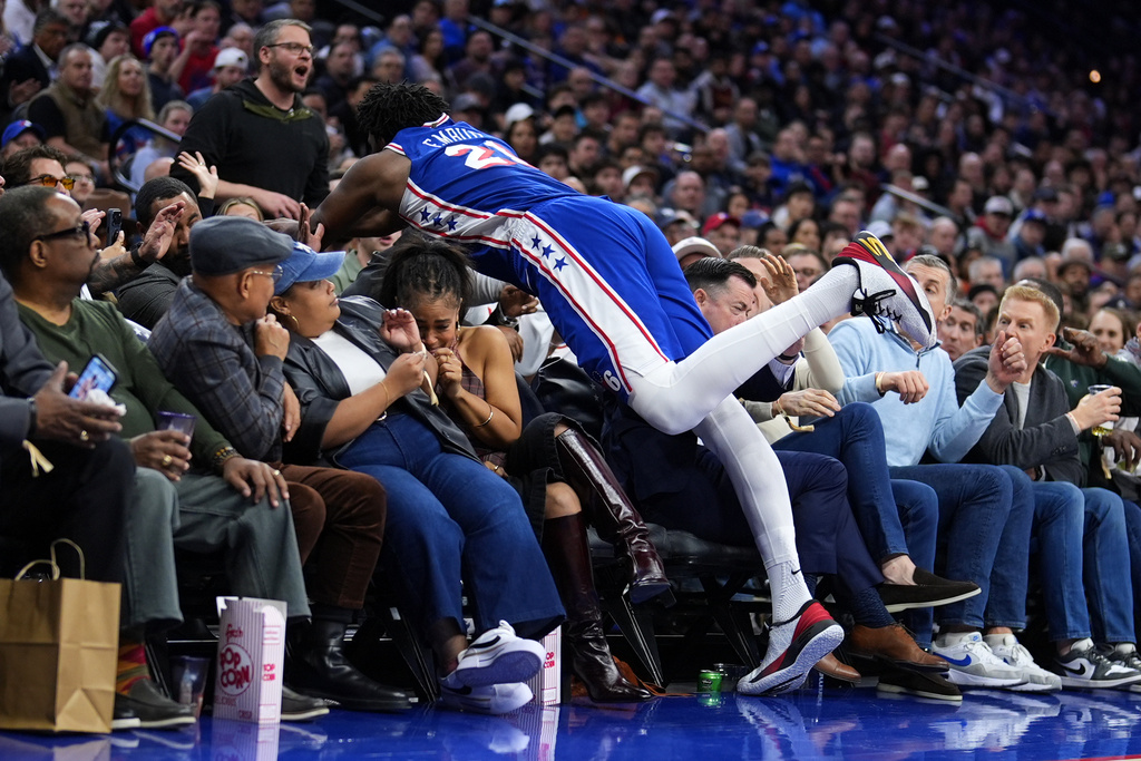 Philadelphia 76ers' Joel Embiid dives into the seat after chasing a loose ball during the second half of an NBA basketball game against the Cleveland Cavaliers Wednesday, Jan. 14, 2026, in Philadelphia. 