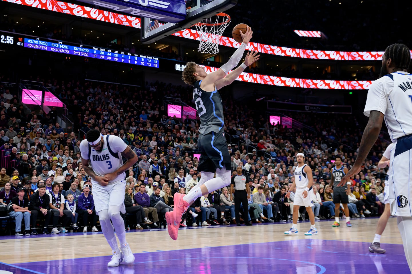 Mavericks' forward Anthony Davis (left) holds his hand in pain as Jazz forward Lauri Markkanen goes up for a layup in the fourth quarter.